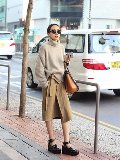 上身超级柔软的米色羊绒毛衣,搭配卡其色半裙,腰间的蝴蝶结设计加强了