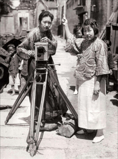 民国十四年(1925年),广州街头,一位中国女摄影师和她的助手.