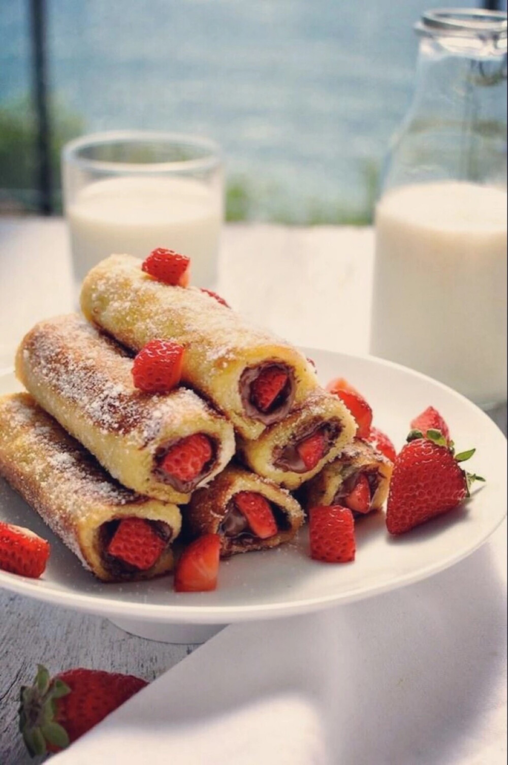 放入平底锅两面煎成金黄,然后涂上巧克力酱,铺上草莓粒,像做寿司一样