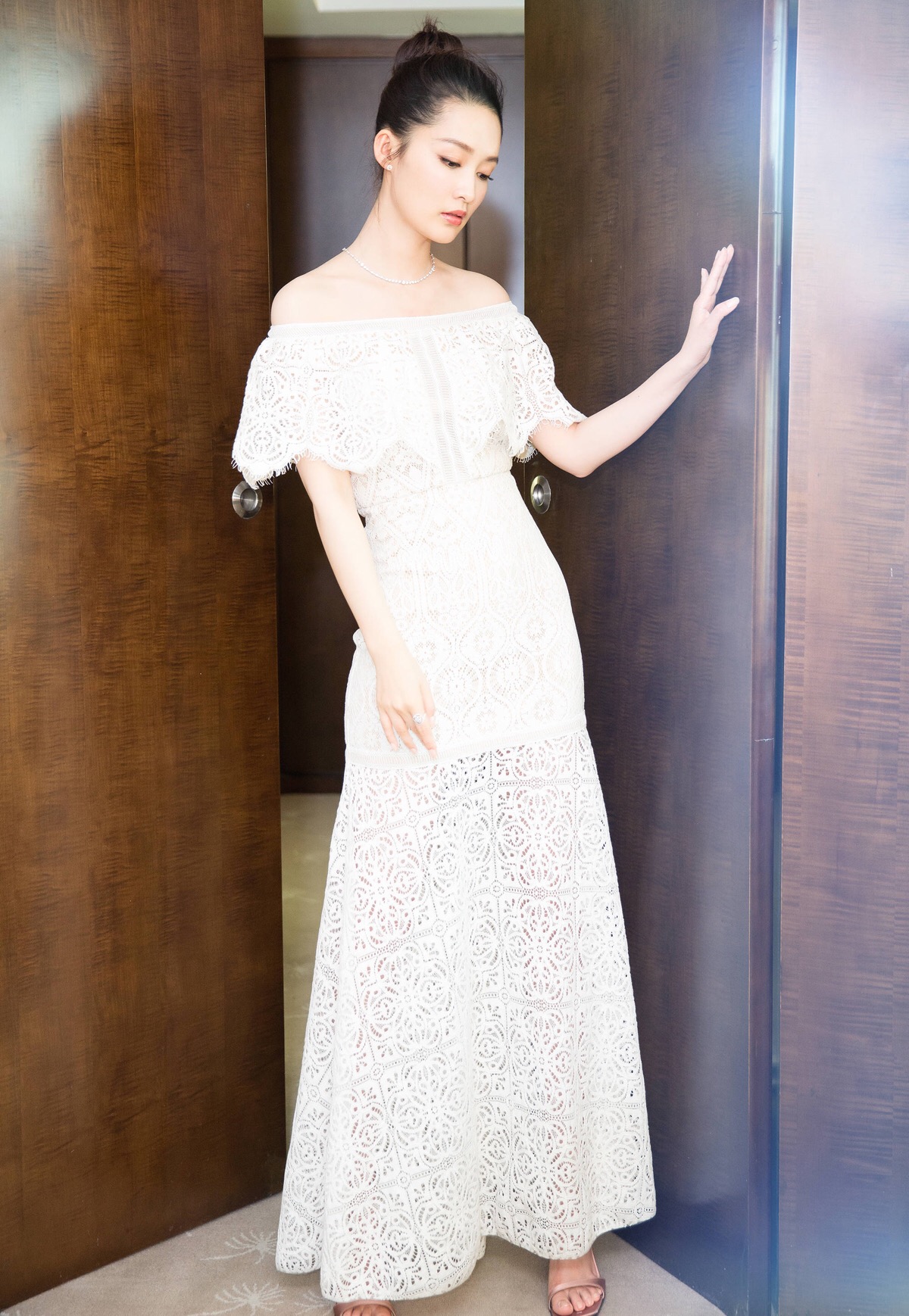 李沁身着一袭白色一字肩荷叶边蕾丝长裙出席活动,别致的玫瑰花纹优雅