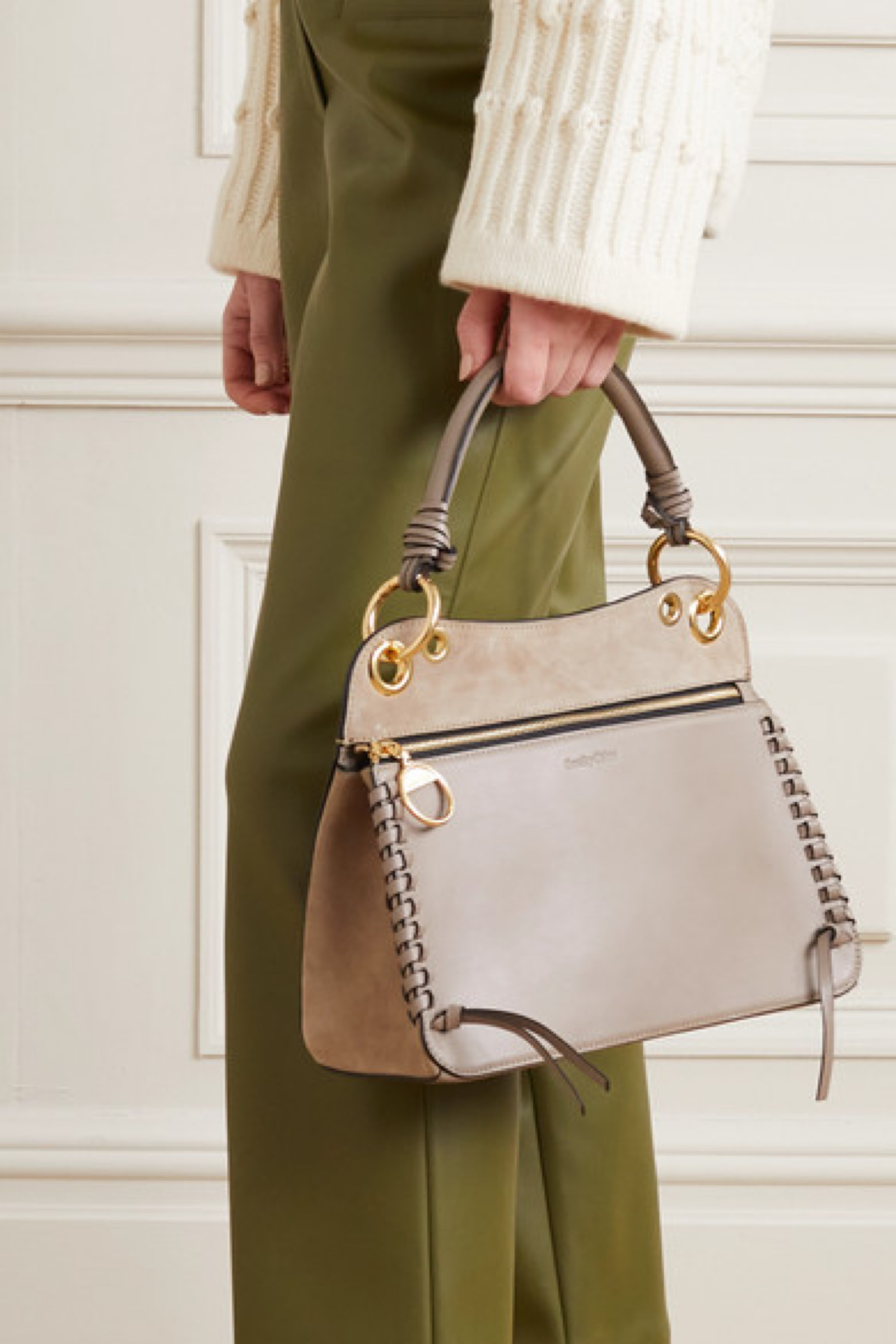 灰色皮革和绒面革拼接而成,配有锁缝边,金色的五金配件上刻着品牌名称