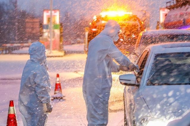 2020年2月15日晚,在g15高速公路连云港市赣榆收费站,防疫人员冒雪对入