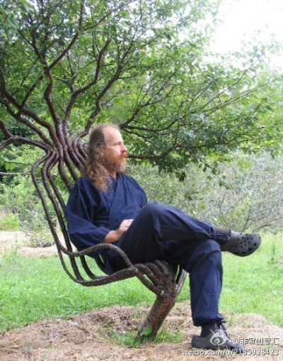 这是世界上第一把用活树做成的椅子,这位老人就是它的设计师.