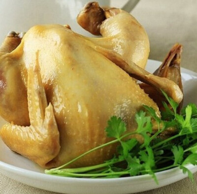 将盐焗鸡粉用麻油调成糊状,抹在鸡的身体内外按摩一会,电饭煲锅底放入