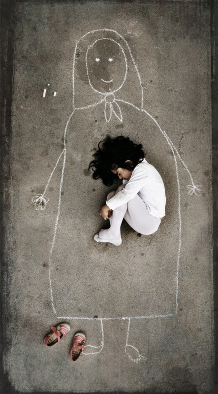 一名孤儿院的孩子,因为从未见过妈妈,她就在地板上画了一个妈妈,想像