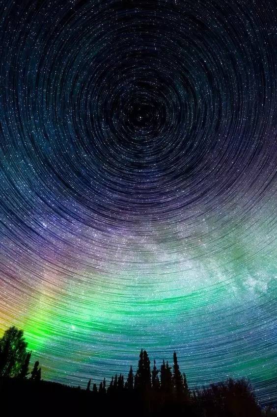 星轨由延时摄影而成,长时间的曝光还原了所有星辰的运行轨迹,而极光在